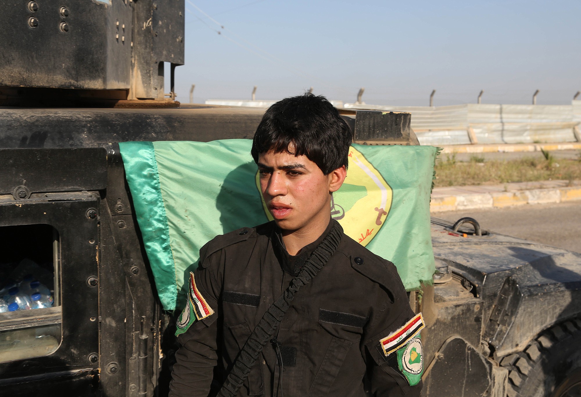 A young Shiite volunteer militiaman stands near a vehicle on his way to the battlefield against Islamic State fighters in Tikrit, Iraq.