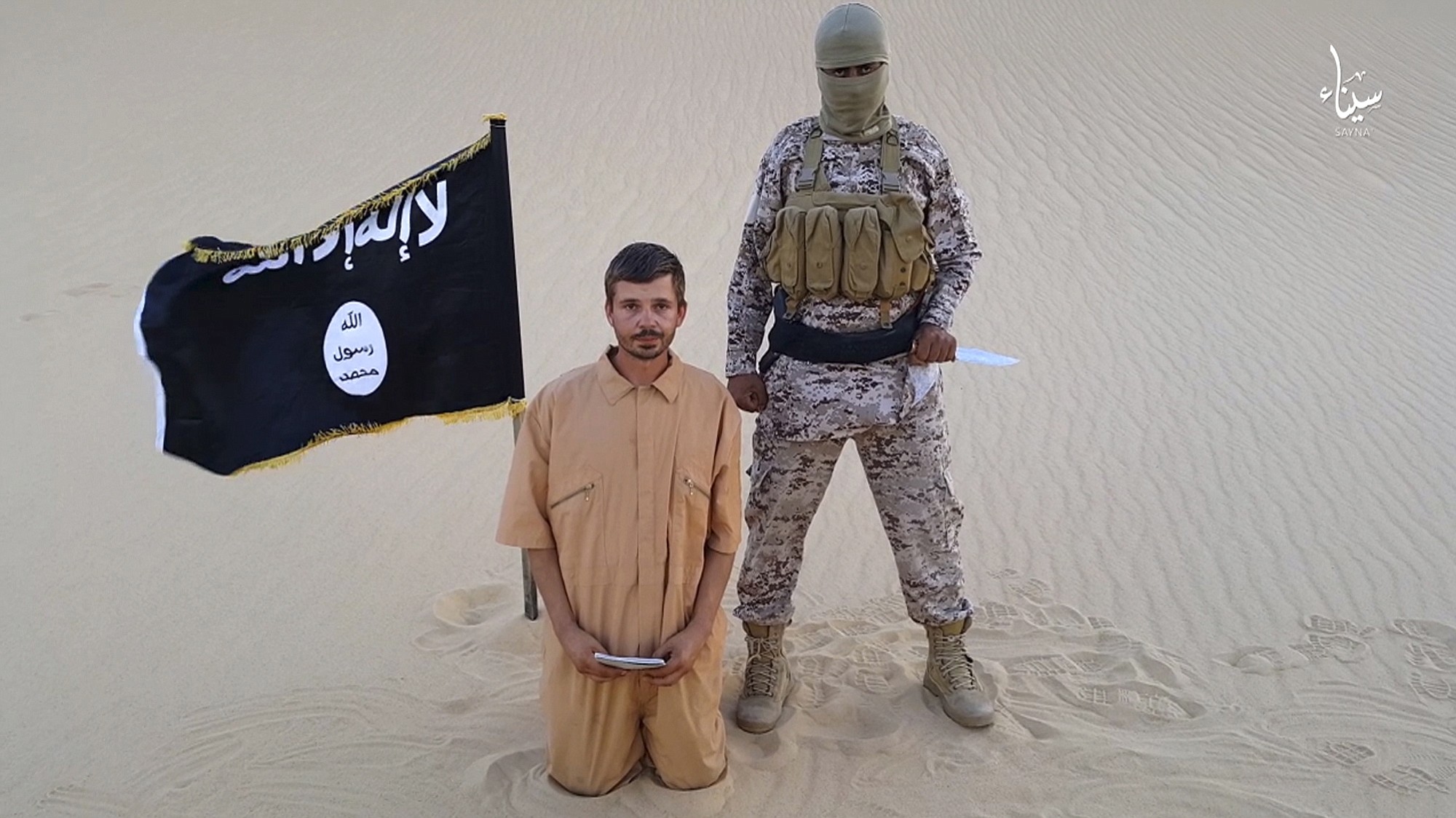 This image made from a militant video posted on a social media site Aug. 5shows a militant standing next to a man who identifies himself as Tomislav Salopek, 30, kneeling down as he reads a message at an unknown location. An online image purports to show the Croatian hostage being held by an Islamic State affiliate in Egypt has been beheaded.