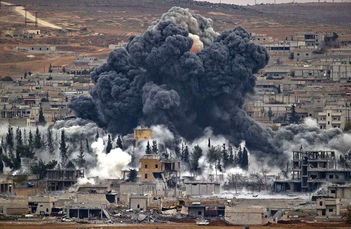 Smoke rises from the Syrian city of Kobani, following a November airstrike by the U.S.-led coalition, seen from a hilltop outside Suruc, on the Turkey-Syria border.