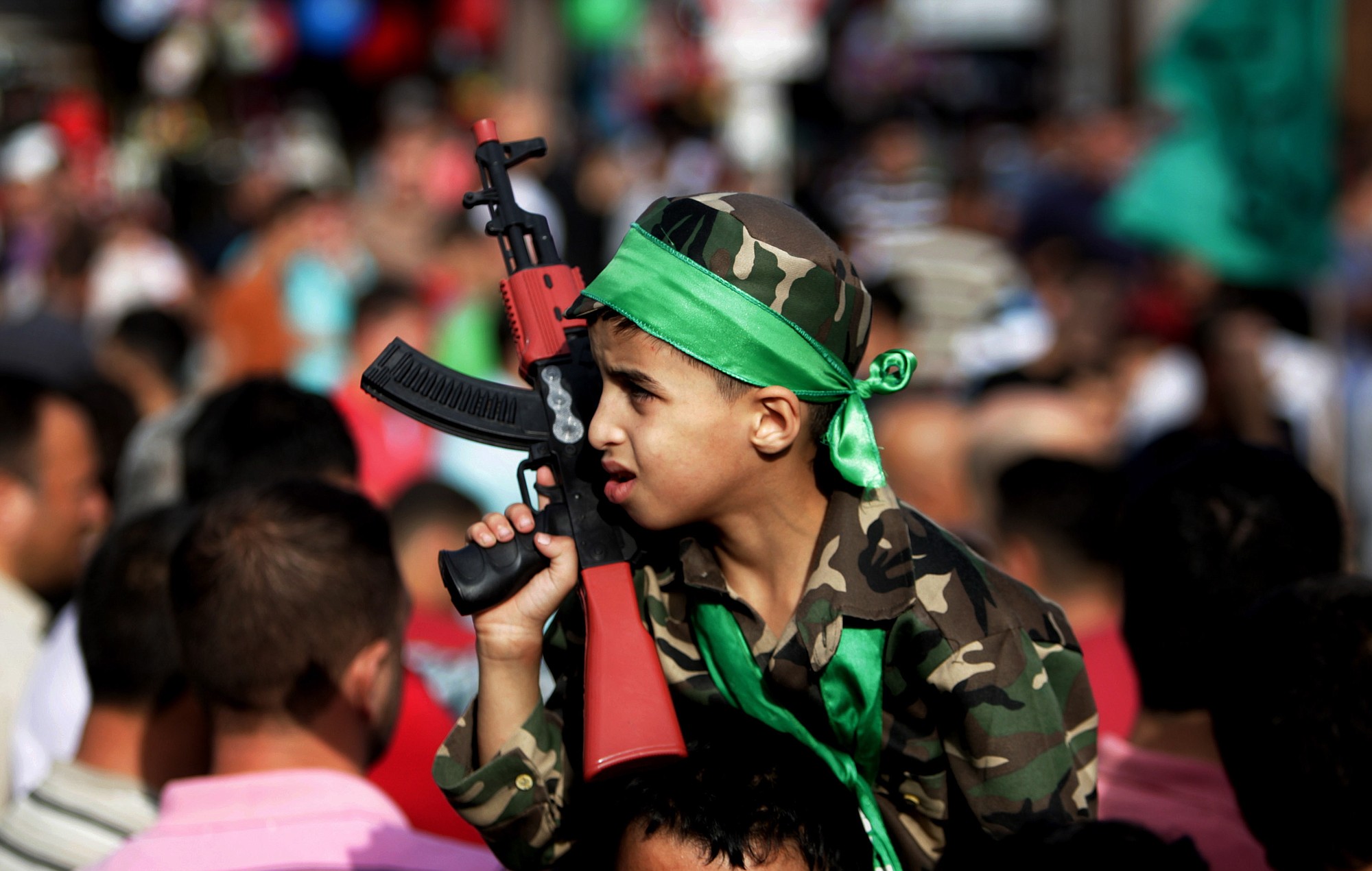 A boy holds a toy gun during a protest against the Gaza war in the West Bank city of Nablus on Monday.