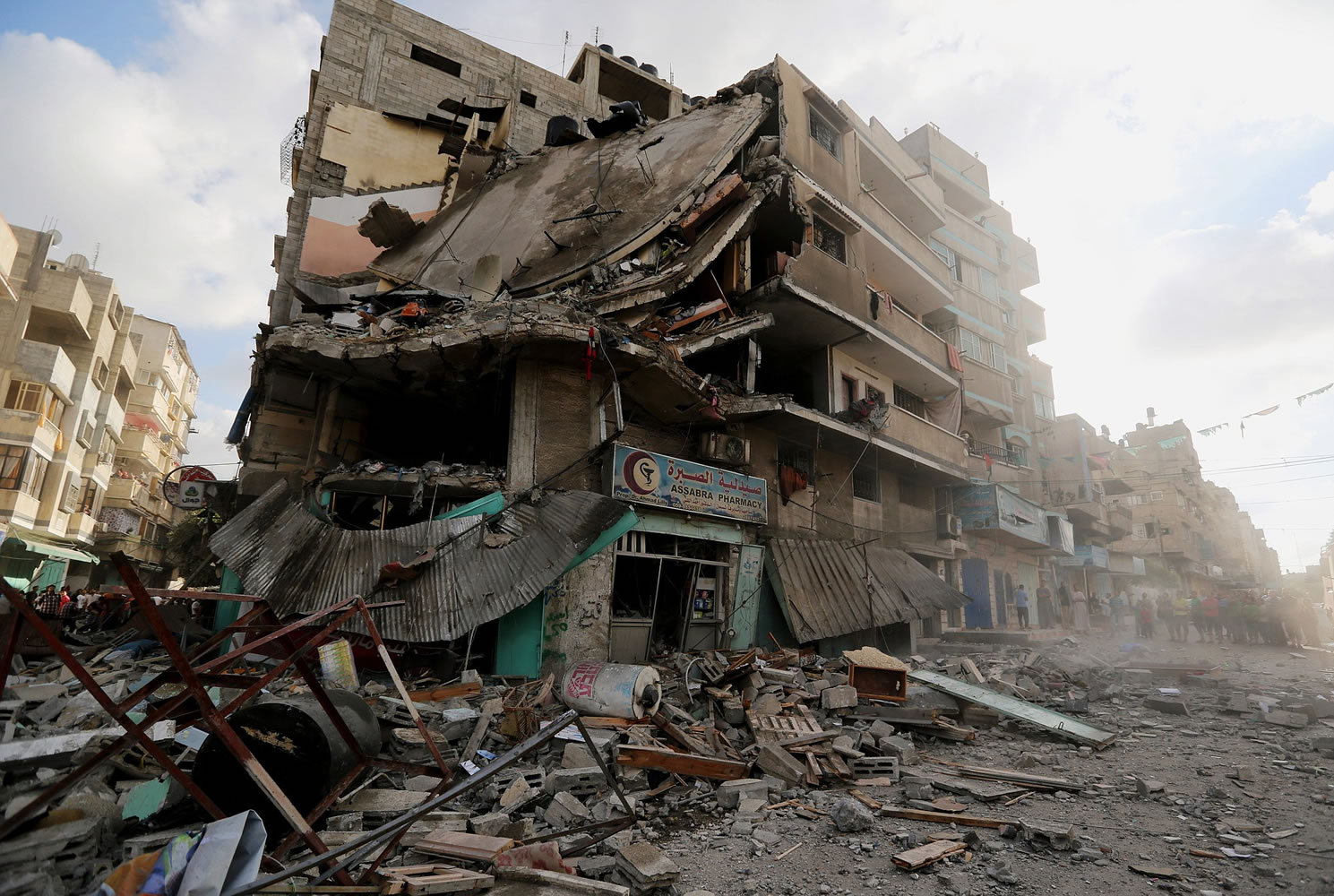 Palestinians inspect damage to an apartment building after it was hit by an Israeli missile strike today in Gaza City. Israeli troops pushed deeper into Gaza on Friday to destroy rocket launching sites and tunnels, firing volleys of tank shells and clashing with Palestinian fighters in a high-stakes ground offensive meant to weaken the enclaveu2019s Hamas rulers.