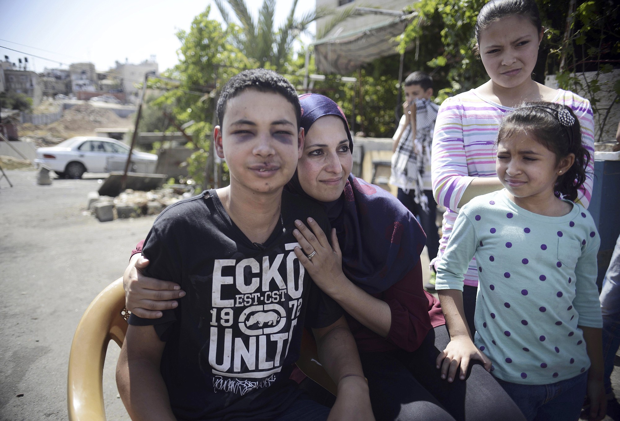 Tariq Abu Khdeir, 15, is hugged by his mother, Suha, after he was released from detention in Jerusalem on Sunday.