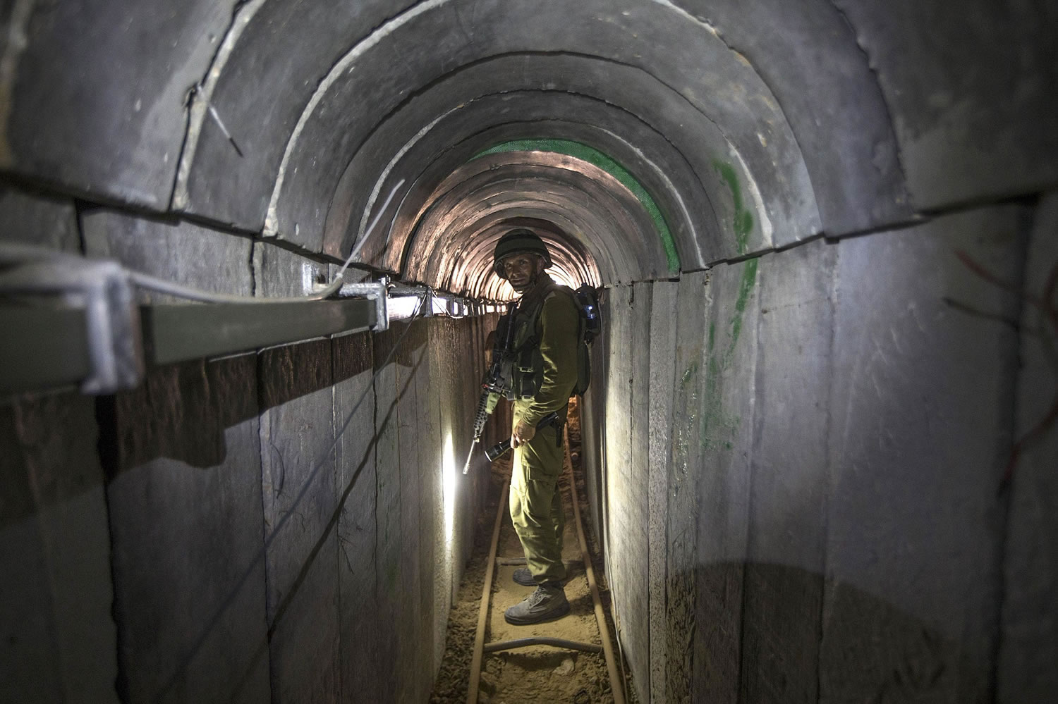 FILE - In this Friday, July 25, 2014 file photo, an Israeli army officer gives journalists a tour of a tunnel allegedly used by Palestinian militants for cross-border attacks, at the Israel-Gaza Border. Hamas is entering Egyptian-brokered talks with Israel over a new border regime for blockaded Gaza having lost hundreds of fighters, two-thirds of its arsenal of rockets, and its attack tunnels.