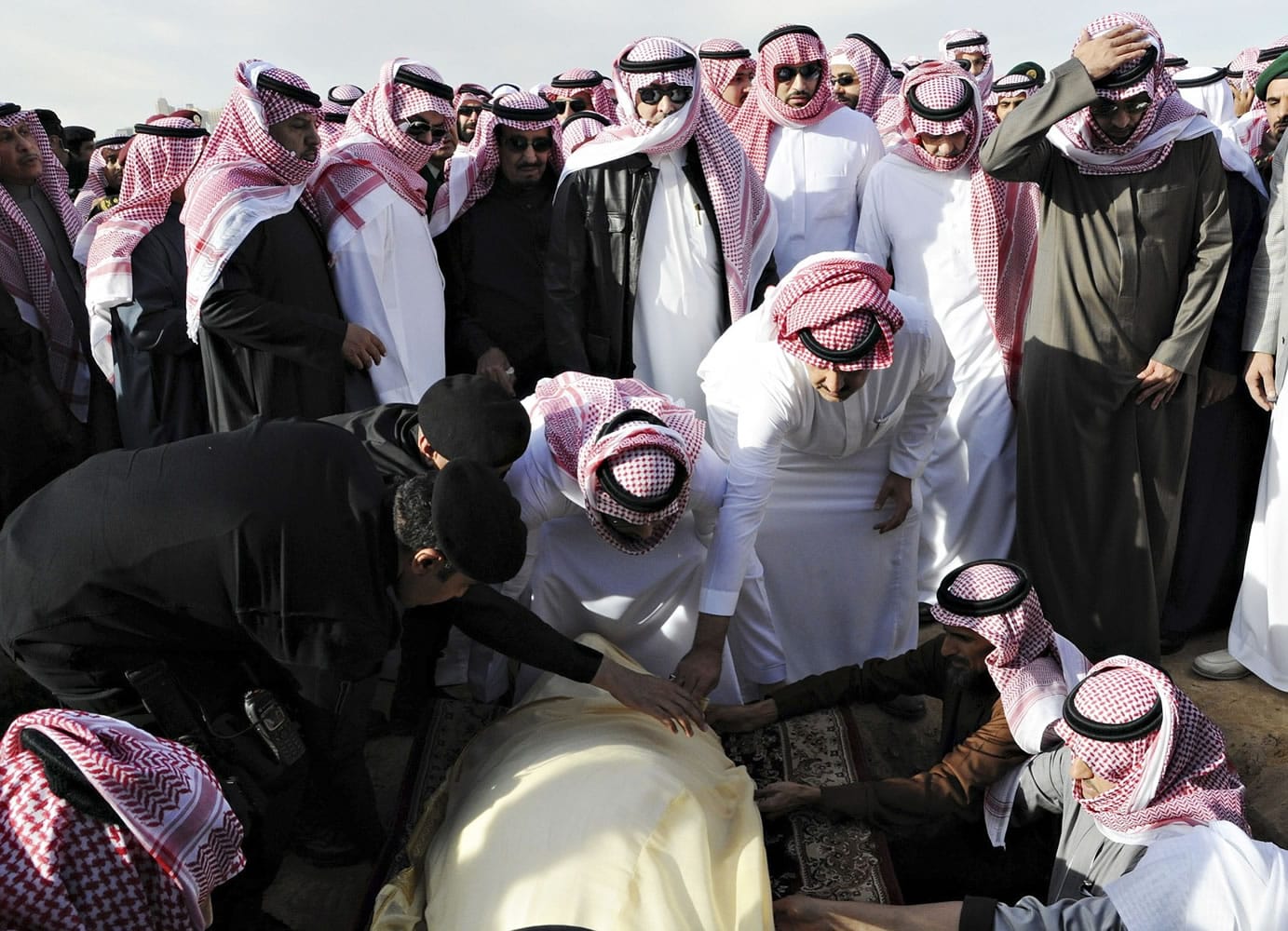 Mourners who carried the body of late King Abdullah put him down before his burial Friday at al-Oud cemetery in Riyadh, Saudi Arabia.