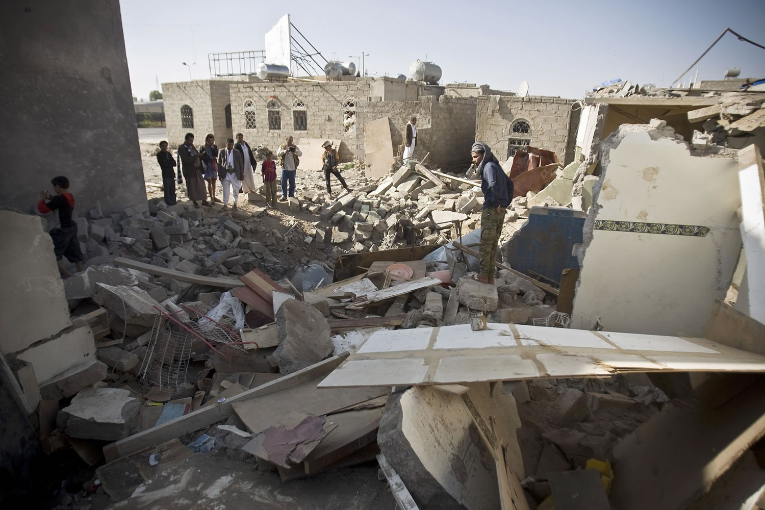 Hadi mohammed/Associated Press
People gather Tuesday near the rubble of houses destroyed by Saudi airstrikes near the airport in Sanaa, Yemen.