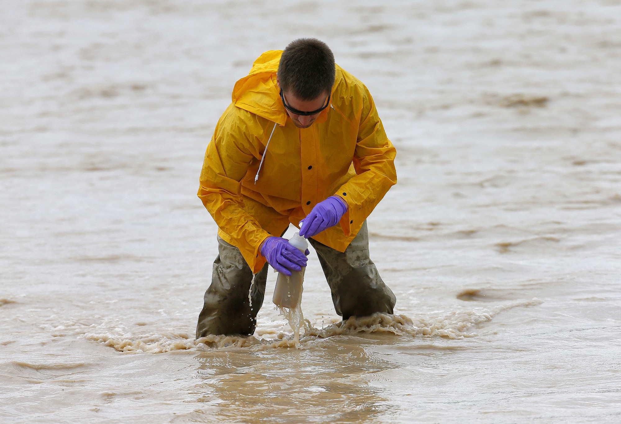 Hydrologic Technician Ryan Parker gathers water samples from the San Juan River, Tuesday, Aug. 11, 2015, in Montezuma Creek, Utah. A spill containing lead and arsenic from the abandoned Gold King Mine in Silverton, Colo., leaked into the Animas River, which flows into the San Juan River in southern Utah, on Aug. 5. The spill was caused by a mining and safety team working for the EPA.