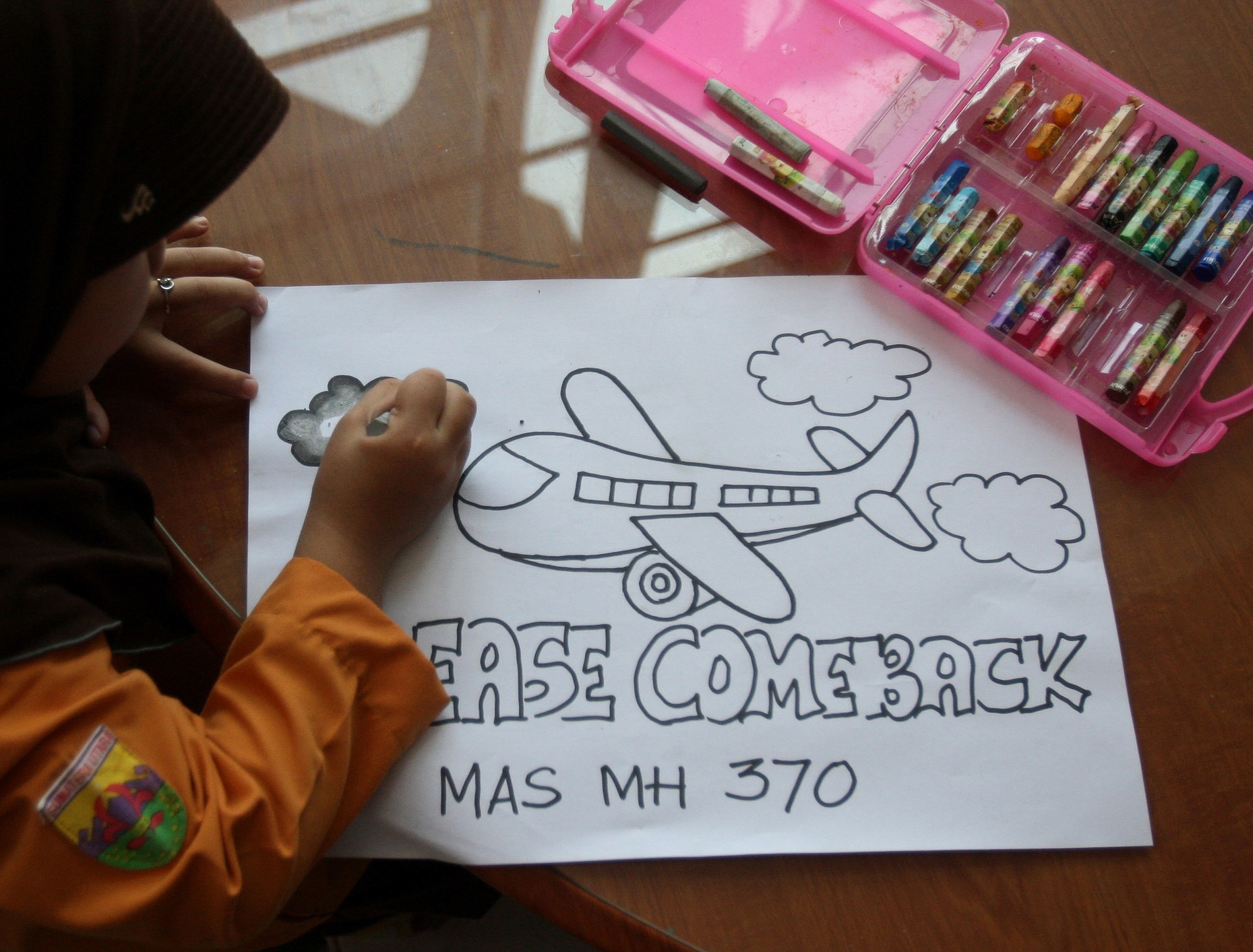 Syira Nazia Hutabarat, 8, works on a picture with for the missing Malaysia Airlines flight MH370 during a class at an elementary school in Medan, North Sumatra, Indonesia.