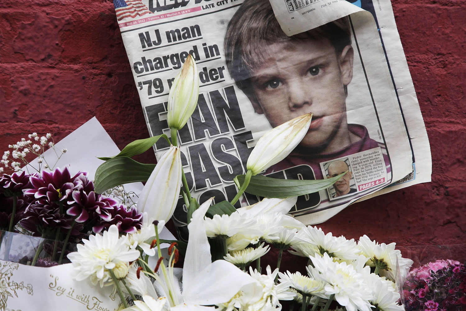 A newspaper with a photograph of Etan Patz is part of a makeshift memorial in the SoHo neighborhood of New York where Patz lived before his disappearance on May 25, 1979. The memorial was set up near a building that housed a convenience store where Pedro Hernandez, accused of killing Patz, told police 33 years after they boy's disappearance that he choked the 6-year-old and put the still-living boy into a plastic bag, boxed up the bag and left it on a street. Opening statements in Hernandez's trial are Friday.