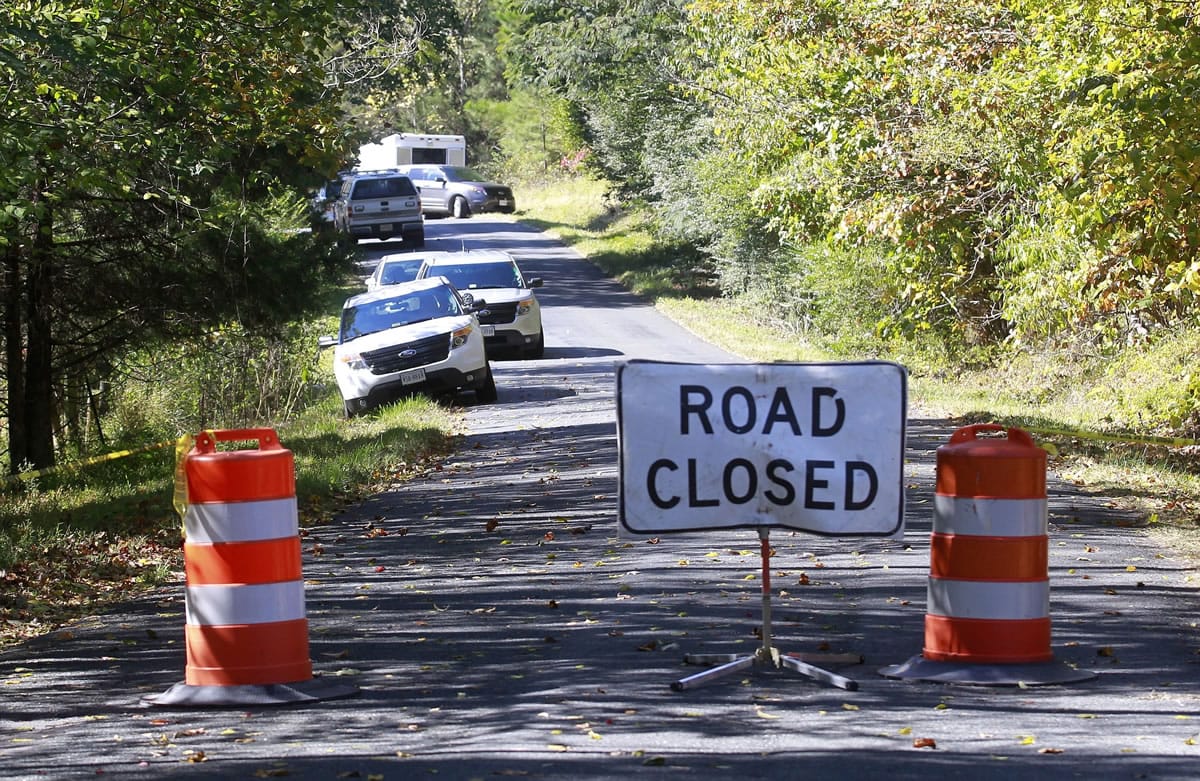 A road closed sign blocks traffic Sunday as authorities search a rural area where human remains were discovered in Albermarle County, Va.
