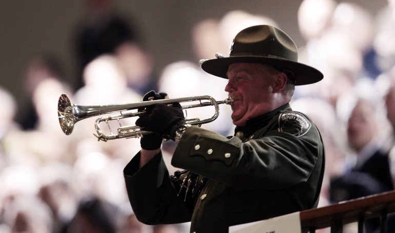 Clark County deputy sheriff Mike Evans plays a trumpet at a memorial service for Mount Rainier National Park Ranger Margaret Anderson Tuesday, Jan. 10, 2012, in Tacoma, Wash. Anderson, a 34-year-old mother of two young girls, was shot and killed  Jan. 1, 2012, after setting up a roadblock to stop a vehicle that blew through a checkpoint on the road to the park's visitor center.