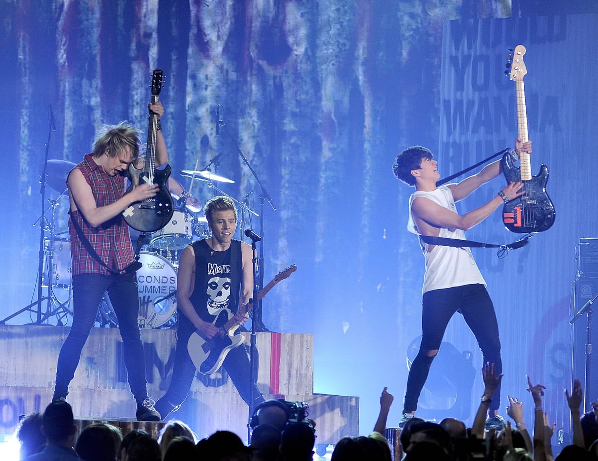 Michael Clifford, from left, Luke Hemmings and Calum Hood, of the musical group 5 Seconds of Summer, perform on stage May 18 at the Billboard Music Awards at the MGM Grand Garden Arena in Las Vegas.