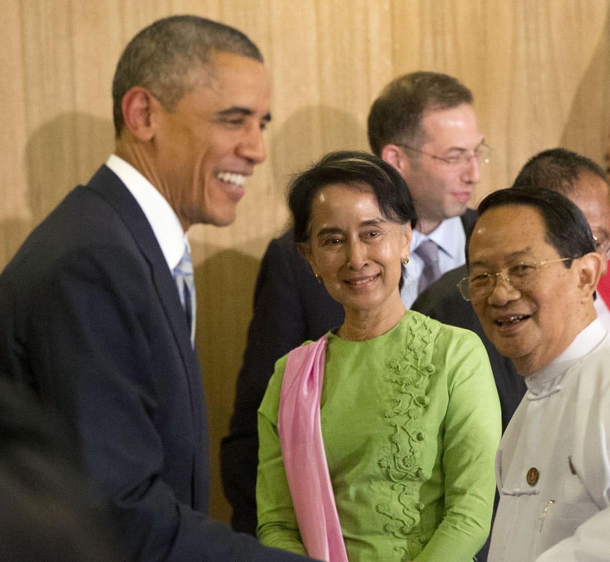 Myanmar's opposition leader Aung San Suu Kyi, center, looks on as President Barack Obama, left, greet participants following a meeting Thursday at Parliamentary Resource Center in Naypyitaw, Myanmar.
