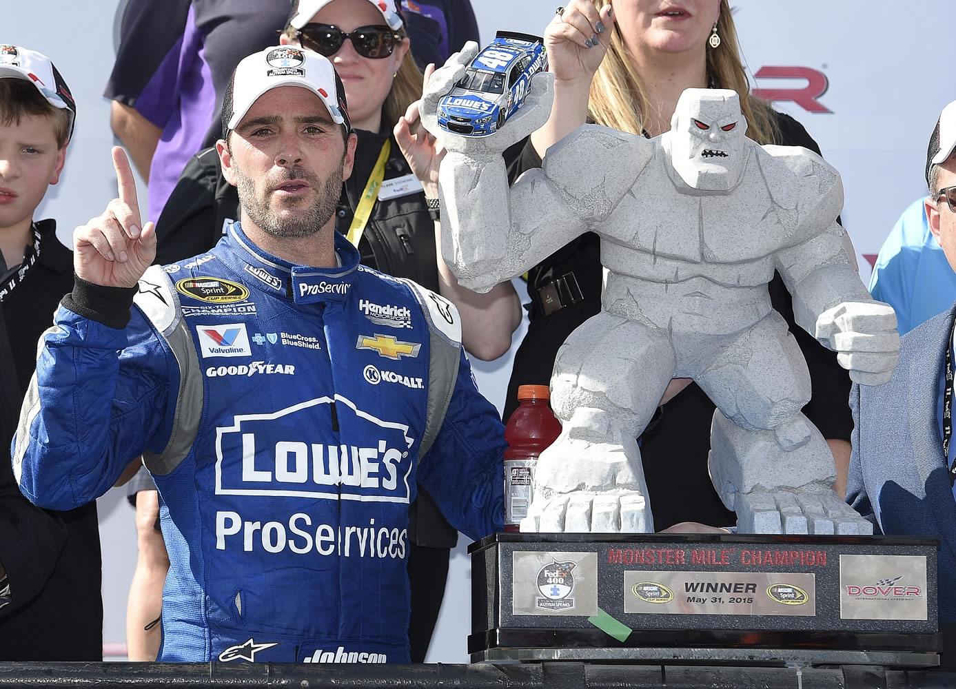 Jimmie Johnson poses with the Monster MIle trophy in Victory Lane after he won the NASCAR Sprint Cup race, Sunday, May 31, 2015, at Dover International Speedway in Dover, Del.