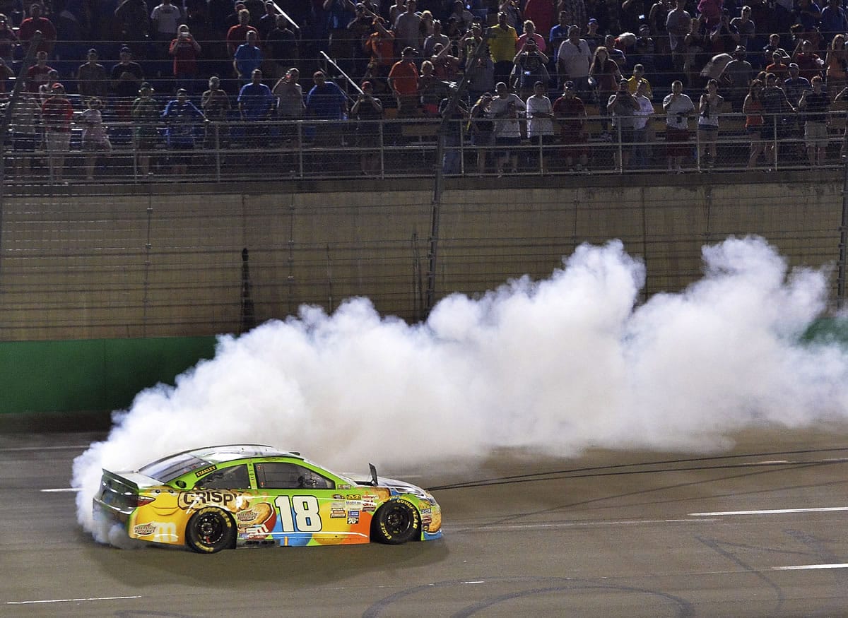 Kyle Busch does a burnout after his victory in the NASCAR Sprint Cup series auto race at Kentucky Speedway in Sparta, Ky., Saturday, July 11, 2015.