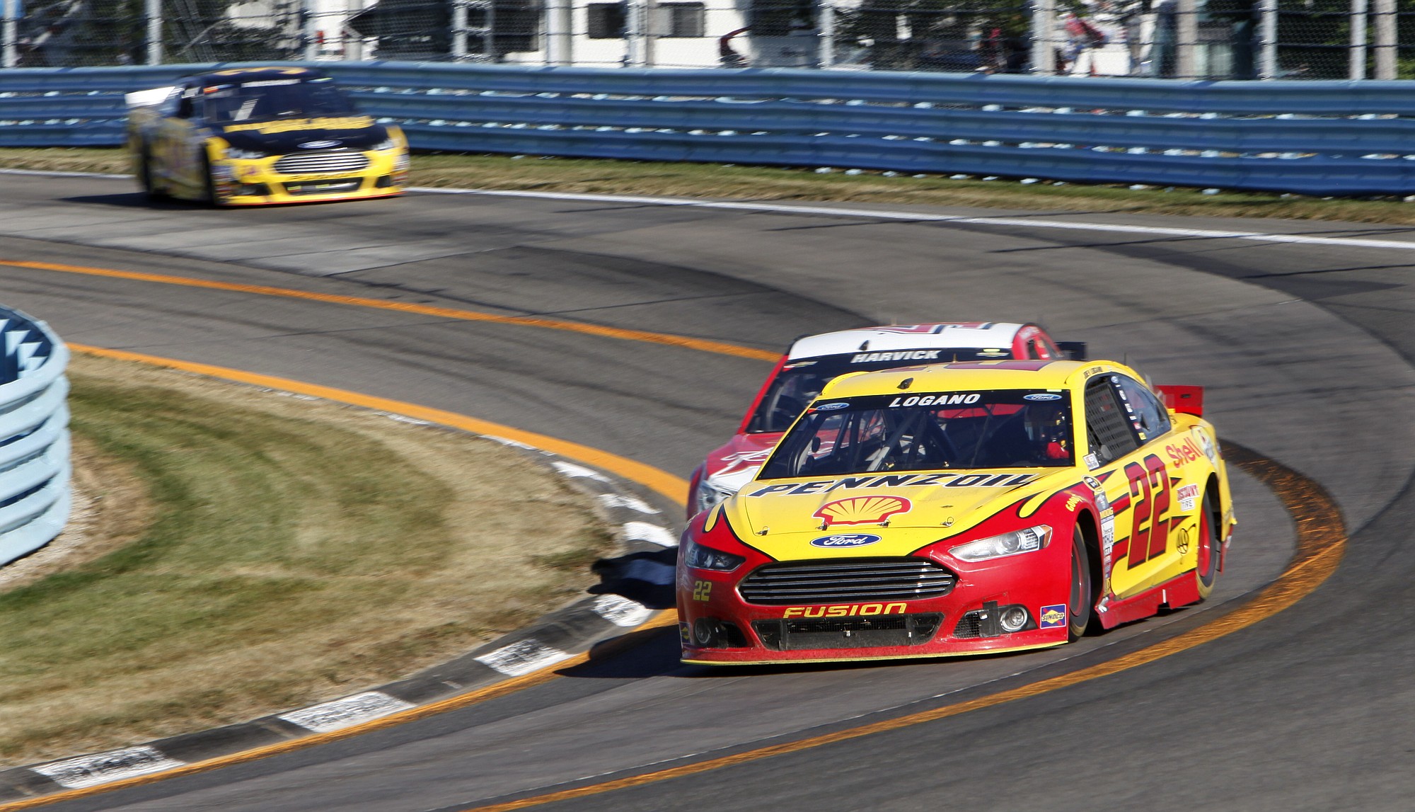 Joey Logano (22) passes Kevin Harvick coming into the last turn on the way to winning a NASCAR Sprint Cup series race at Watkins Glen International, Sunday, Aug. 9, 2015, in Watkins Glen, N.Y.