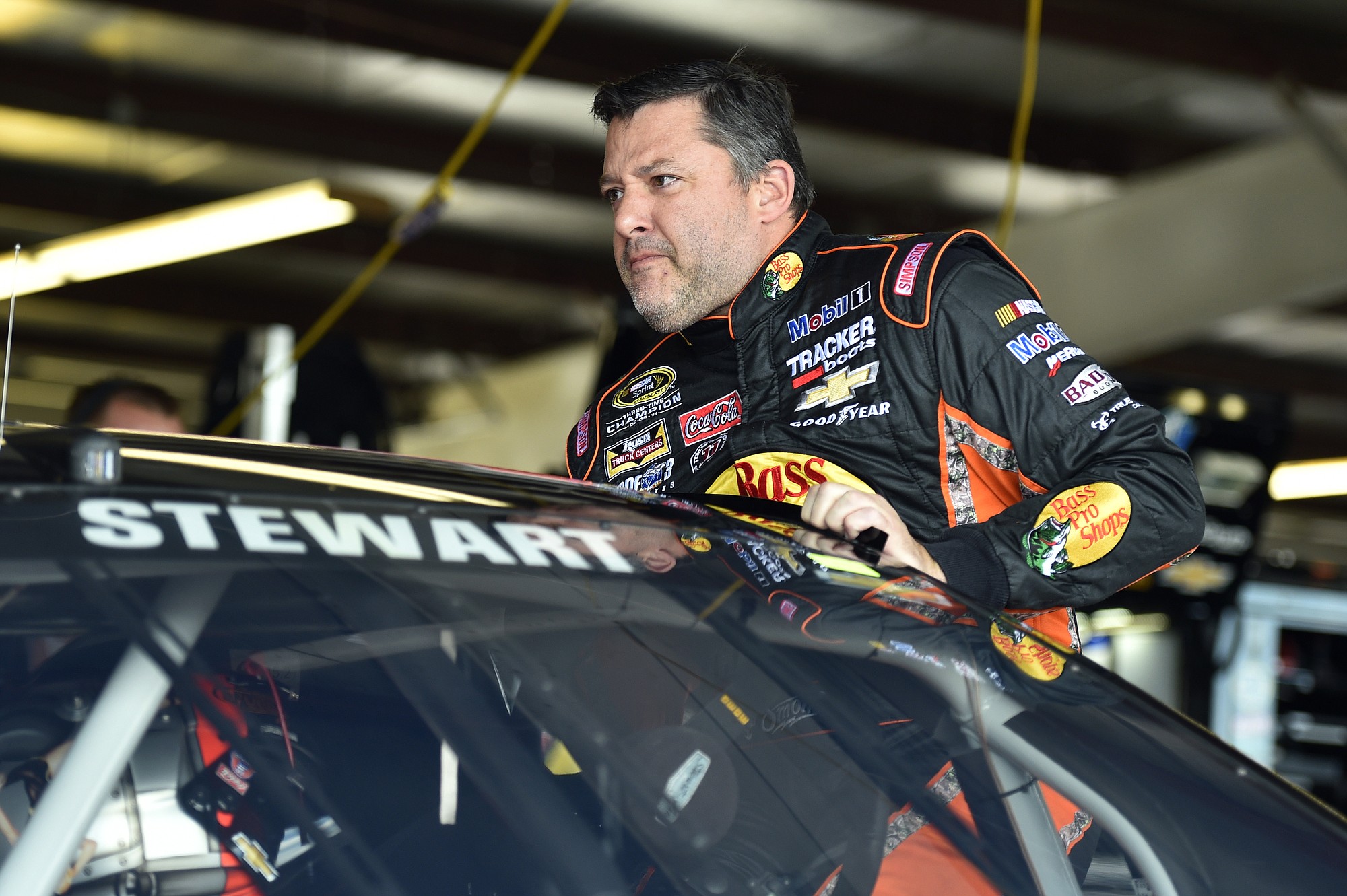 Tony Stewart climbs into his car before practice for Sunday's NASCAR Sprint Cup race at Watkins Glen International, Friday, Aug.