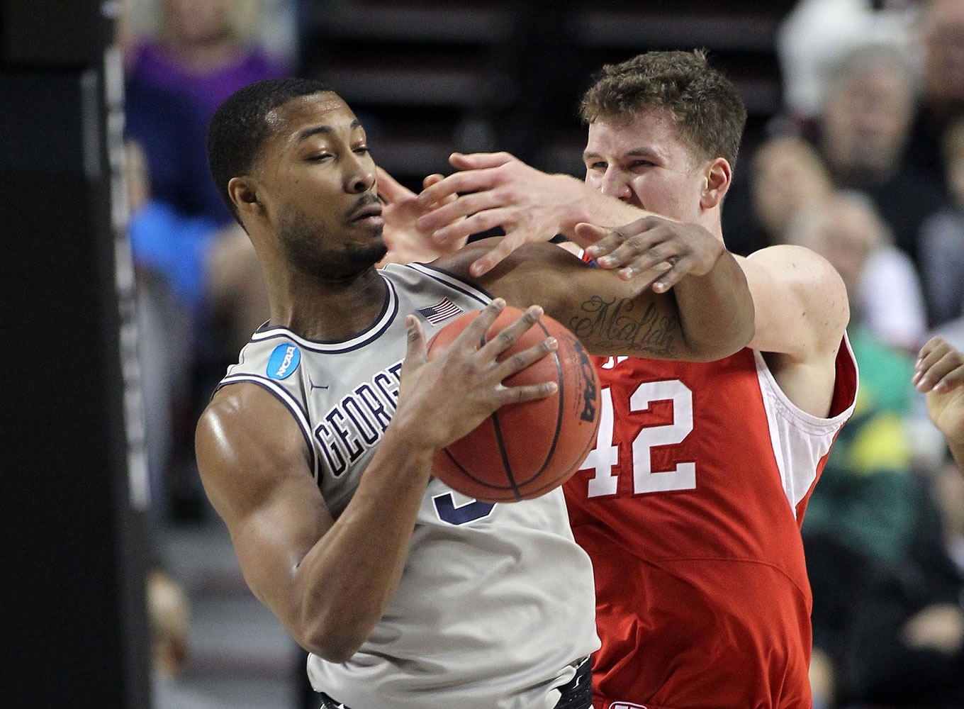 Georgetown forward Mikael Hopkins, left, fights for the ball with Jakob Poeltl during the first half of an NCAA college basketball tournament round of 32 game in Portland, Ore., Saturday, March 21, 2015.