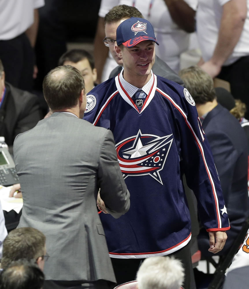 Portland Winterhawks winger Paul Bittner shakes hands with an executive after being chosen 38th overall by the Columbus Blue Jackets during the second round of the NHL draft on Saturday, June 27, 2015, in Sunrise, Fla.
