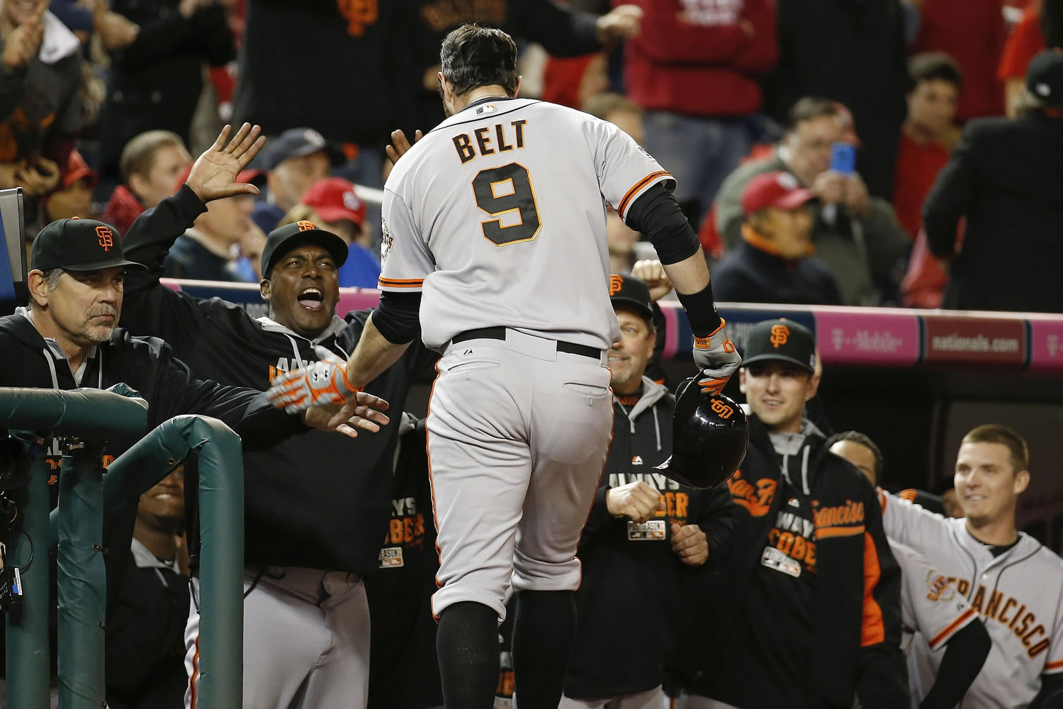 San Francisco Giants' Brandon Belt (9) is cheered as he returns to the dugout after his solo home run in the 18th inning of Game 2 of the NL Division Series against the Washington Nationals in Nationals Park, Saturday, Oct. 4, 2014, in Washington.