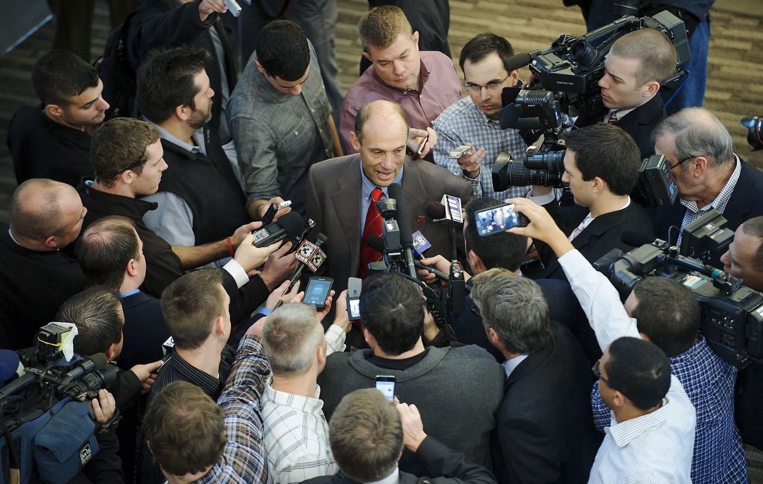 Nebraska's new football coach Mike Riley is swarmed by the media after a news conference at Memorial Stadium on Friday, Dec. 5, 2014 in Lincoln, Neb. Riley, who came from Oregon State, replaces Bo Pelini who was fired last Sunday.