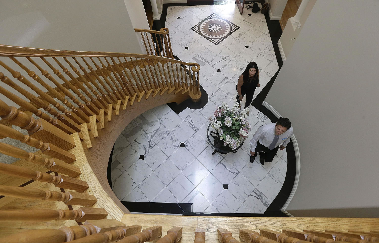 In this May 6, 2015 photo, realtor Stephan Marshall, bottom, walks with potential buyer Sasha Martinez at a home for sale in Pacifica, Calif. A rising stock market and climbing home prices boosted Americans' net worth to a new high in the first three months of the year, according to a Federal Reserve report released Thursday, June 11, 2015.