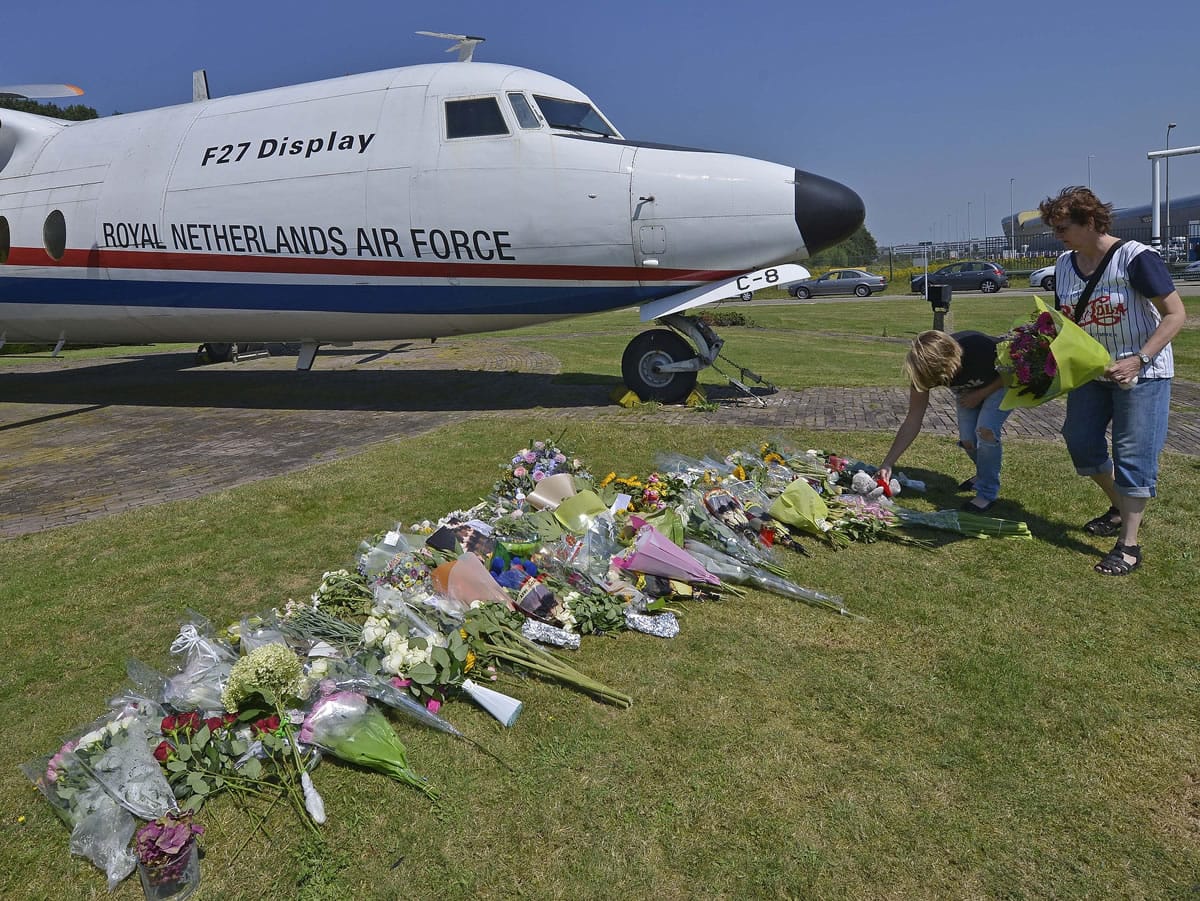 People lay flowers in front of a plane prior to a ceremony Wednesday at Eindhoven military air base to mark the return of the first bodies of passengers and crew killed in the downing of Malaysia Airlines Flight 17.