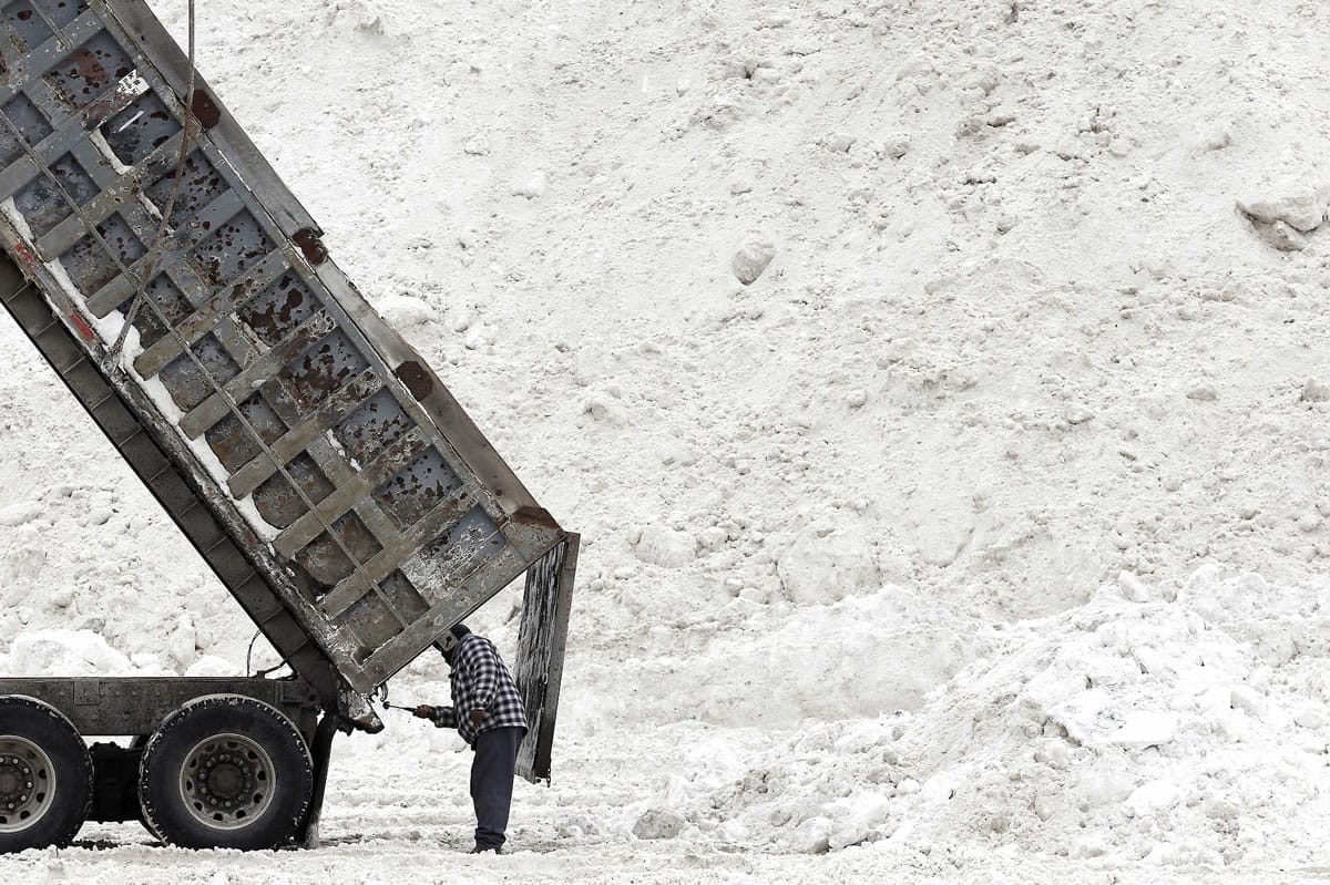 Evon Daley, of Hartford, Conn., clears his truck after unloading snow at a &quot;snow farm&quot; in Boston, Saturday, Feb. 14, 2015. Crews from around the region have worked urgently to remove the massive amounts of snow that has clogged streets and triggered numerous roof collapses ahead of yet another winter storm due to arrive on Saturday.