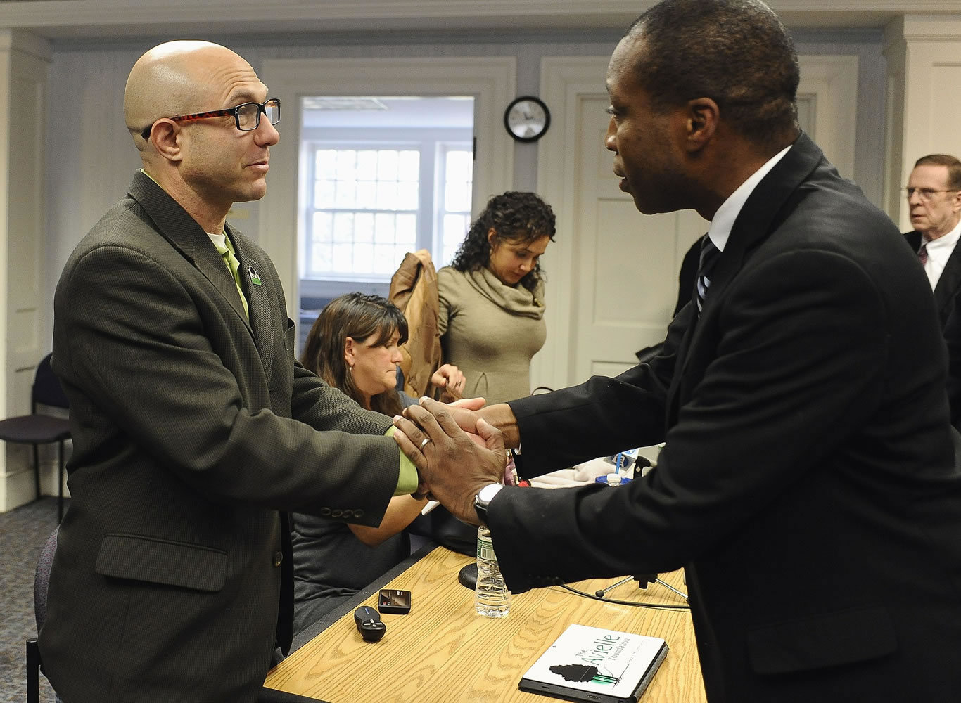 Jeremy Richman, father of Sandy Hook Elementary school shooting victim Avielle Richman, left, shakes hands with Scott Jackson, Chairman of the Sandy Hook Advisory Commission after meeting, Friday, Nov. 14, 2014, in Newtown, Conn. The parents of two children killed made presentations on ways to better address mental health, school safety and gun violence prevention.