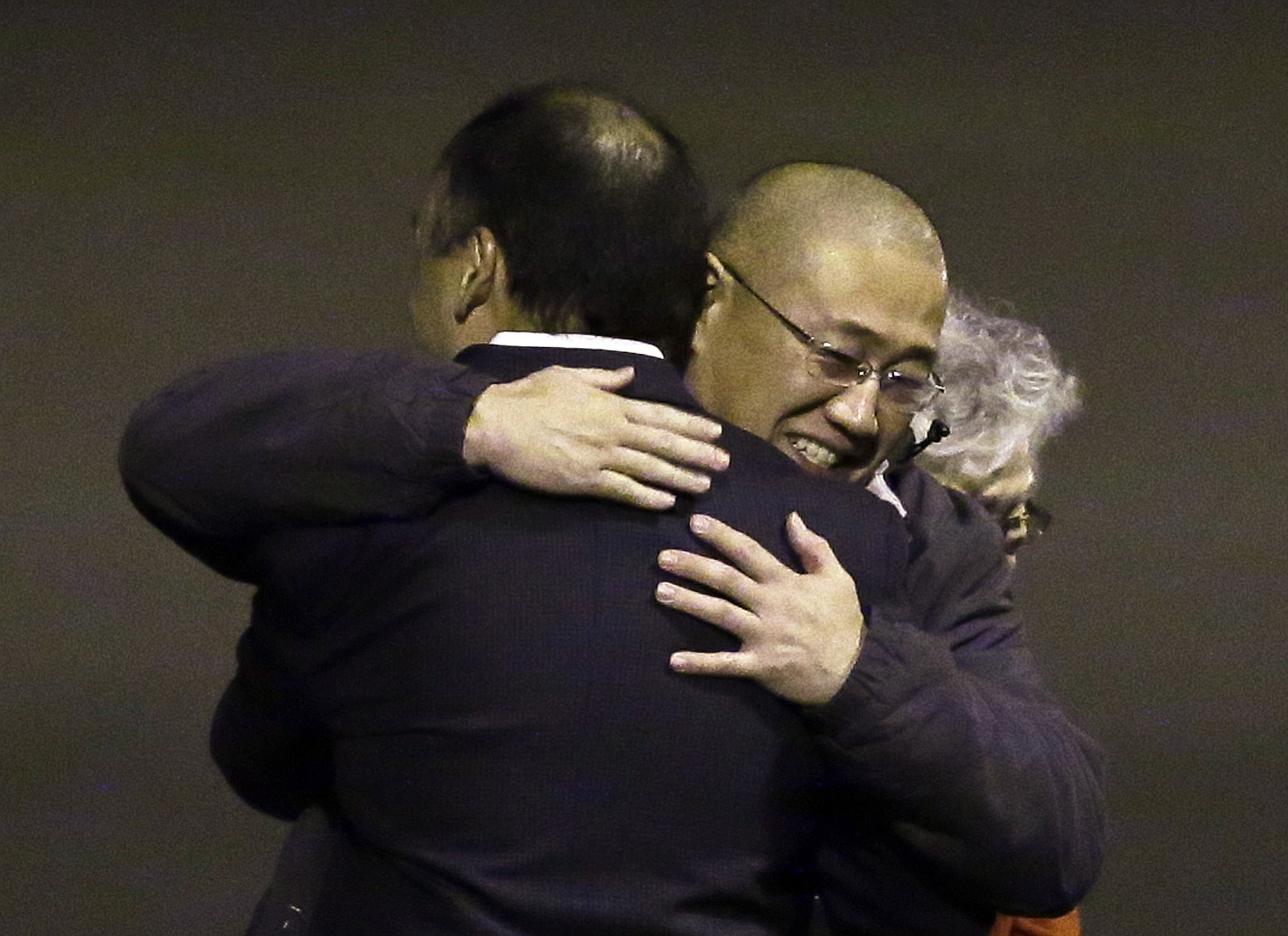 Kenneth Bae, center, who had been held in North Korea since 2012, is hugged after arriving Saturday, Nov.