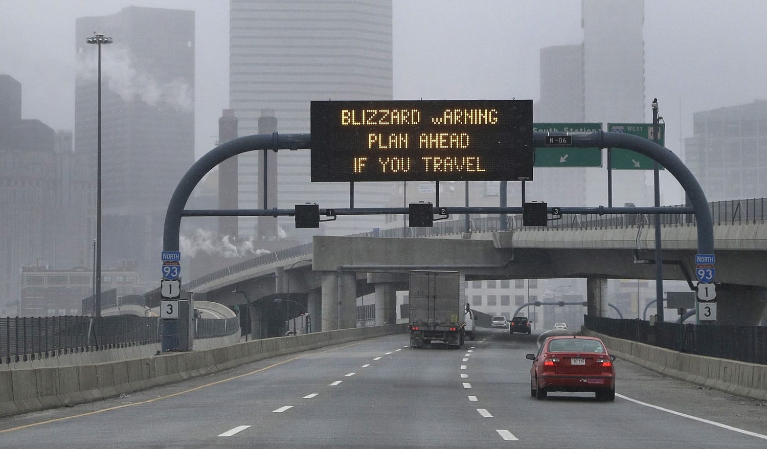 A warning sign flashes for motorists on the expressway into Boston as snow starts to fall on Friday.