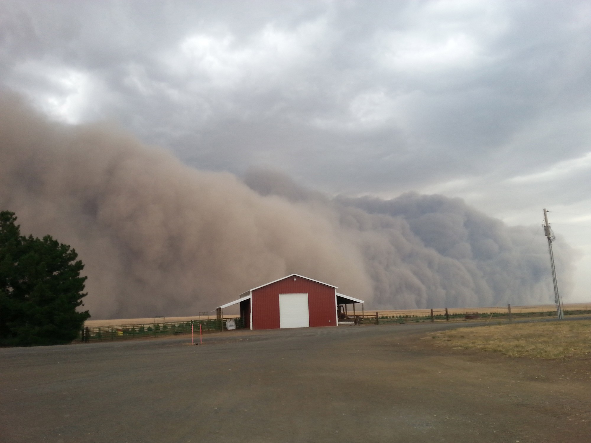 A massive, dramatic dust storm moves toward a barn near Harrington on Tuesday, Aug. 12.