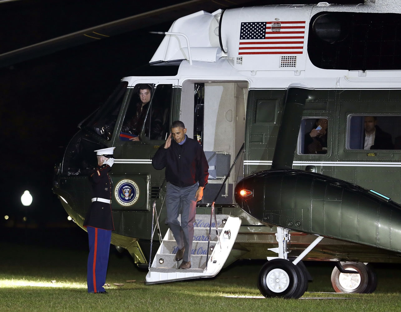 President Barack Obama salutes as he steps from Marine One onto the South Lawn of the White House, in Washington, on Sunday as he returns from Brisbane, Australia, by way of Hawaii and Andrews Air Force Base, Md.