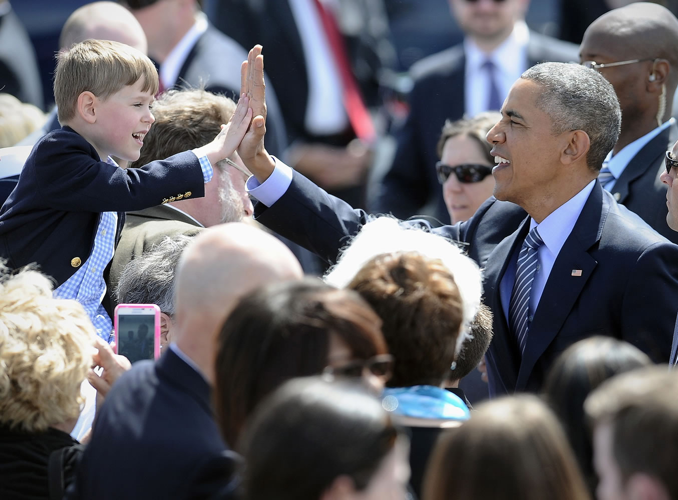 President Barack Obama high-fives Trey Vance, 5, of Waterbury, Conn., after arriving at Groton-New London Airport on Wednesday in Groton, Conn. Tomorrow is Vance's sixth birthday.
