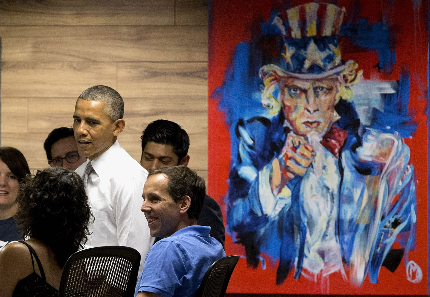 President Barack Obama stands next to a painting of Uncle Sam during a Thursday visit with workers at 1776, a hub for tech startups, in Washington.
