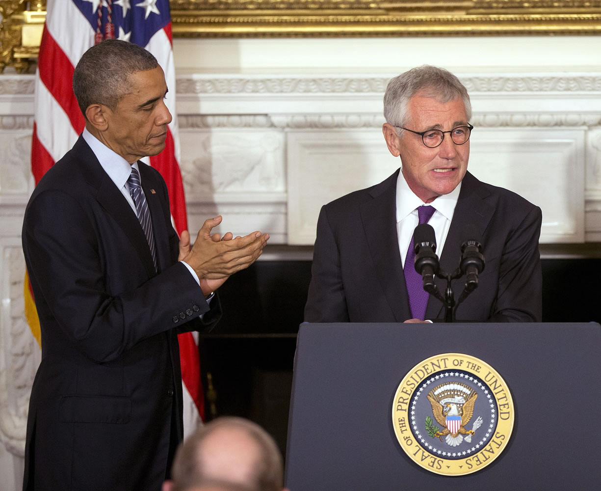President Barack Obama, left, applaudes Defense Secretary Chuck Hagel, right, in the State Dining Room of the White House in Washington on Monday.