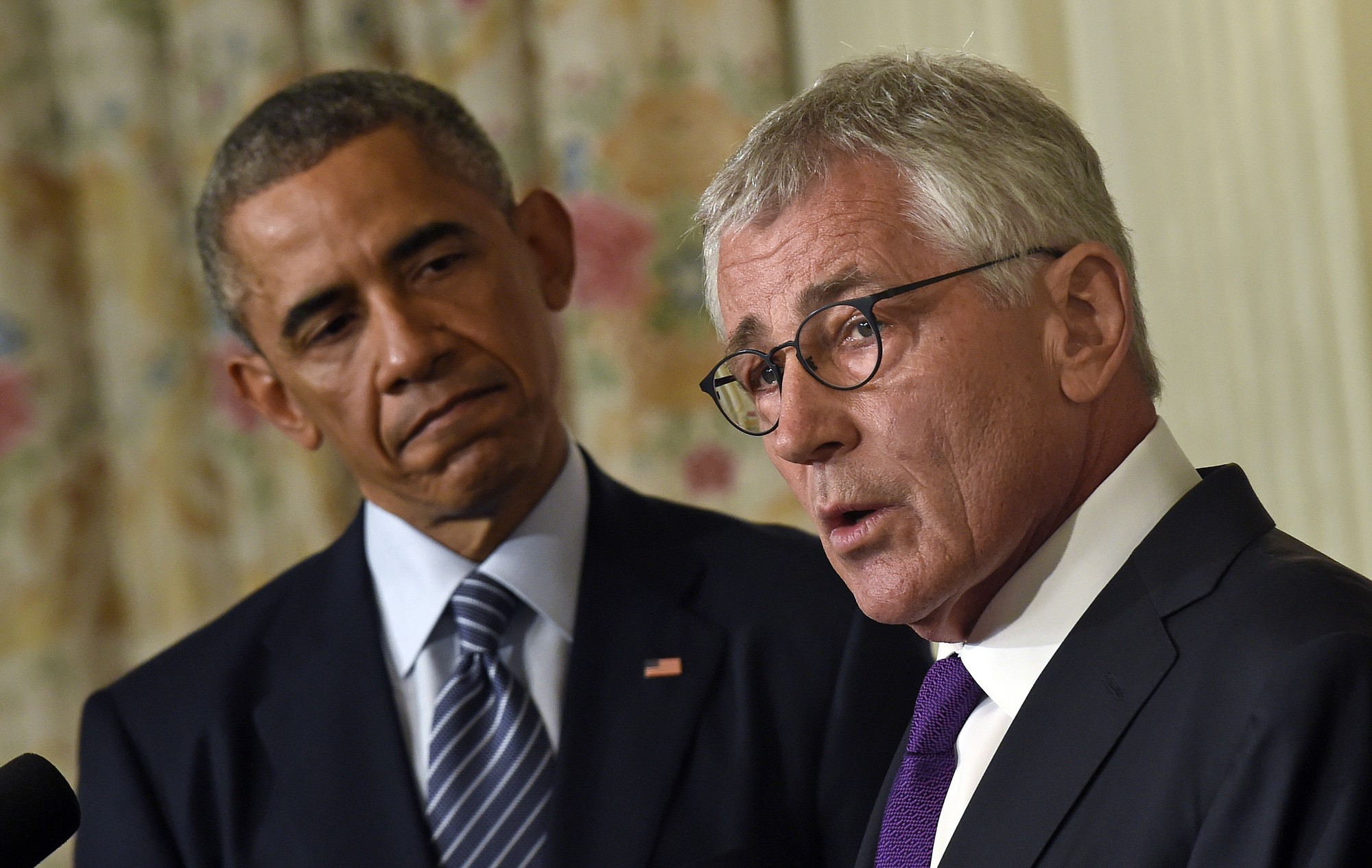 President Barack Obama listens as his third Defense Secretary Chuck Hagel, right, talks about his resignation Monday in Washington.
