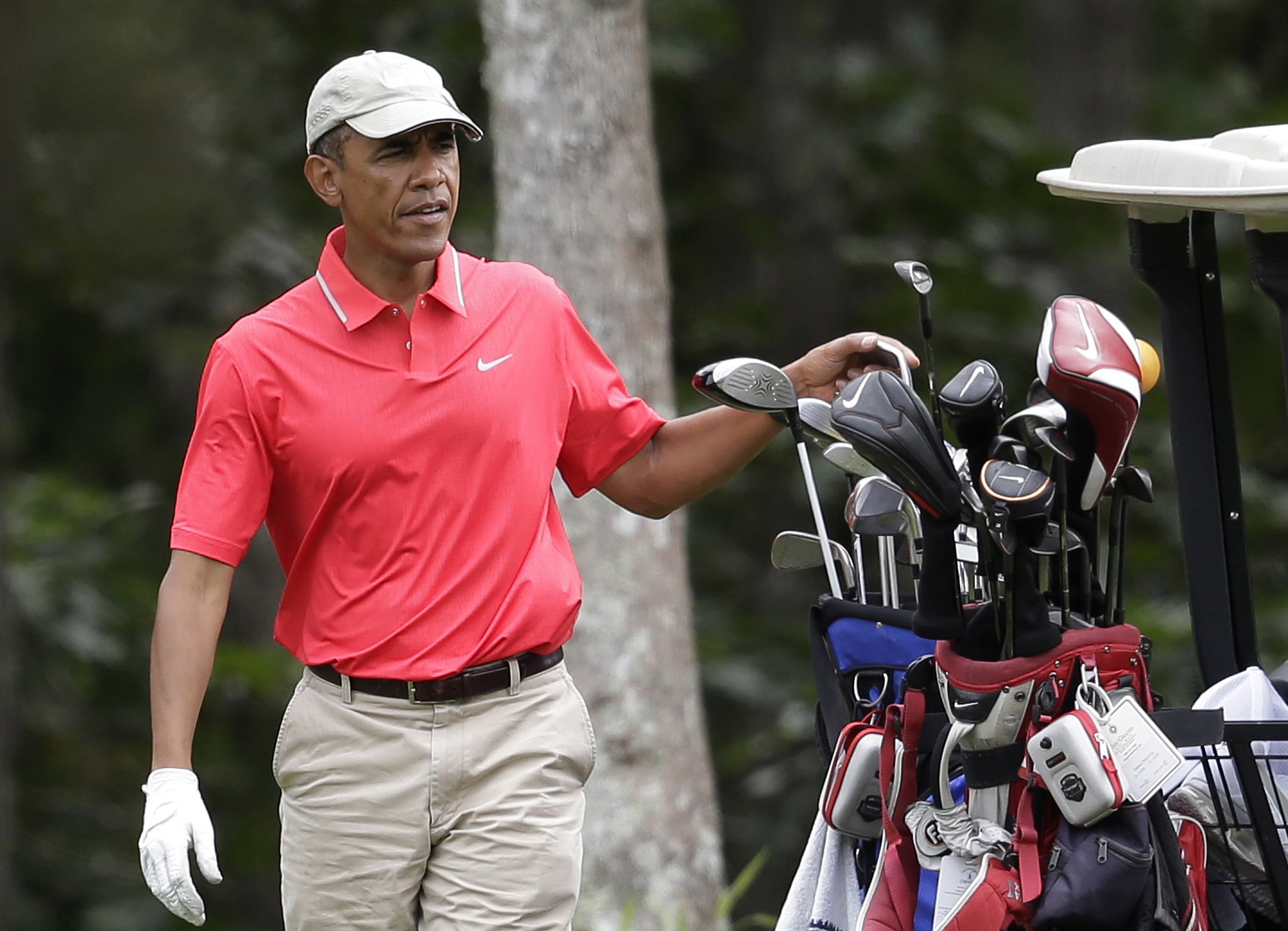 President Barack Obama, wearing a Nike golf shirt, selects a club while golfing Aug. 23 at Farm Neck Golf Club, in Oak Bluffs, Mass., on the island of Martha's Vineyard.
