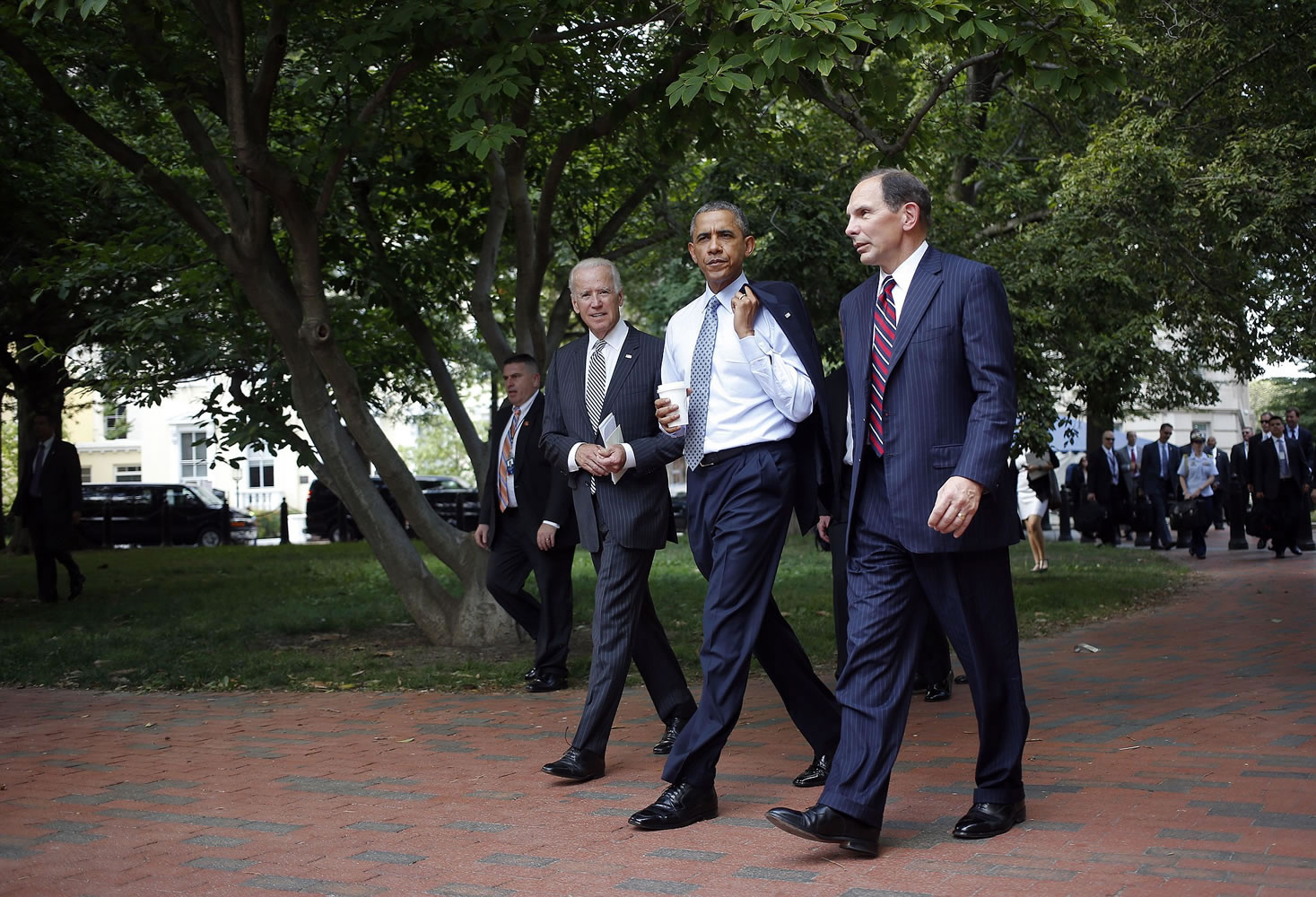 President Barack Obama and Vice President Joe Biden walk with Procter and Gamble executive Robert McDonald, Obama's nominee as the next Veterans Affairs secretary, from the Department of Veterans Affairs across Lafayette Park back to the White House in Washington, Monday, June 30, 2014. If confirmed by the Senate, McDonald would succeed Eric Shinseki, the retired four-star general who resigned last month as the scope of the issues at veterans' hospitals became apparent.