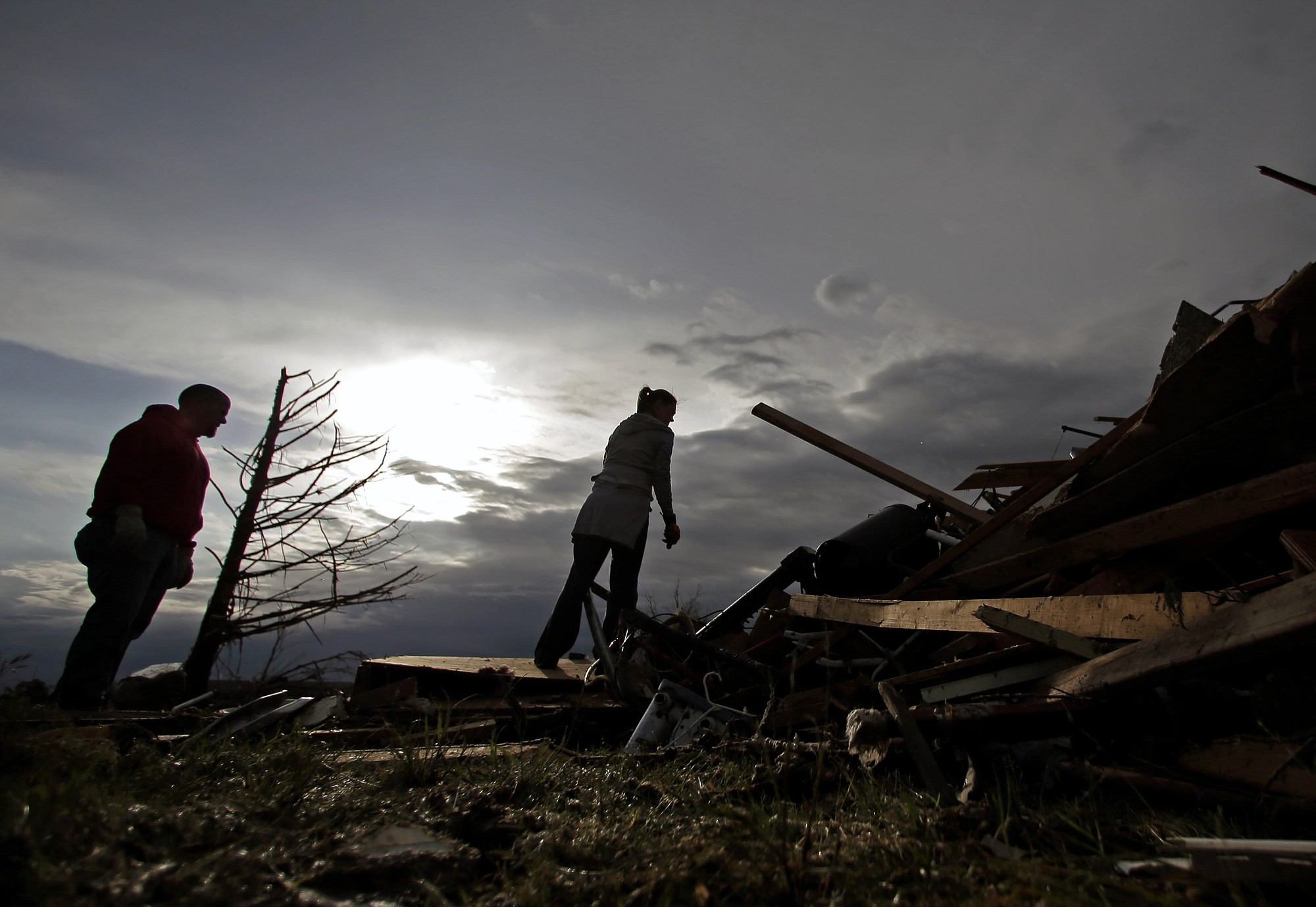 Zac and Denisha Woodcock look through the rubble of a tornado-ravaged rental home which they own Tuesday in Moore, Okla.
