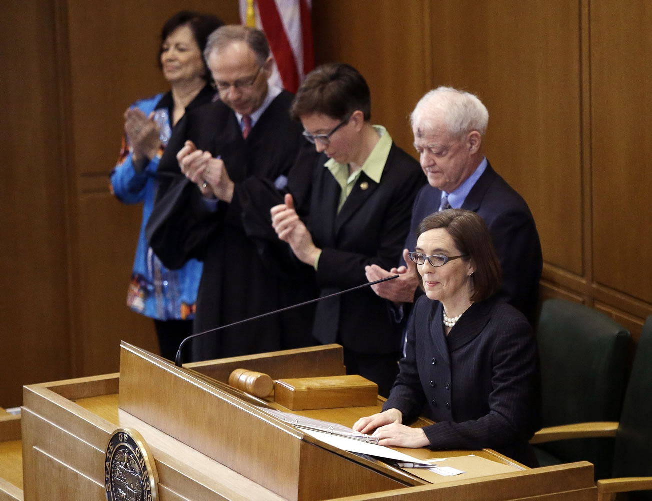 Oregon Gov. Kate Brown stands at the House podium after she is sworn in as Governor in Salem, Ore., Wednesday, Feb. 18, 2015. John Kitzhaber, elected to an unprecedented fourth term last year, announced last week that he would step down amid allegations his fiancee used her relationship with him to enrich herself.