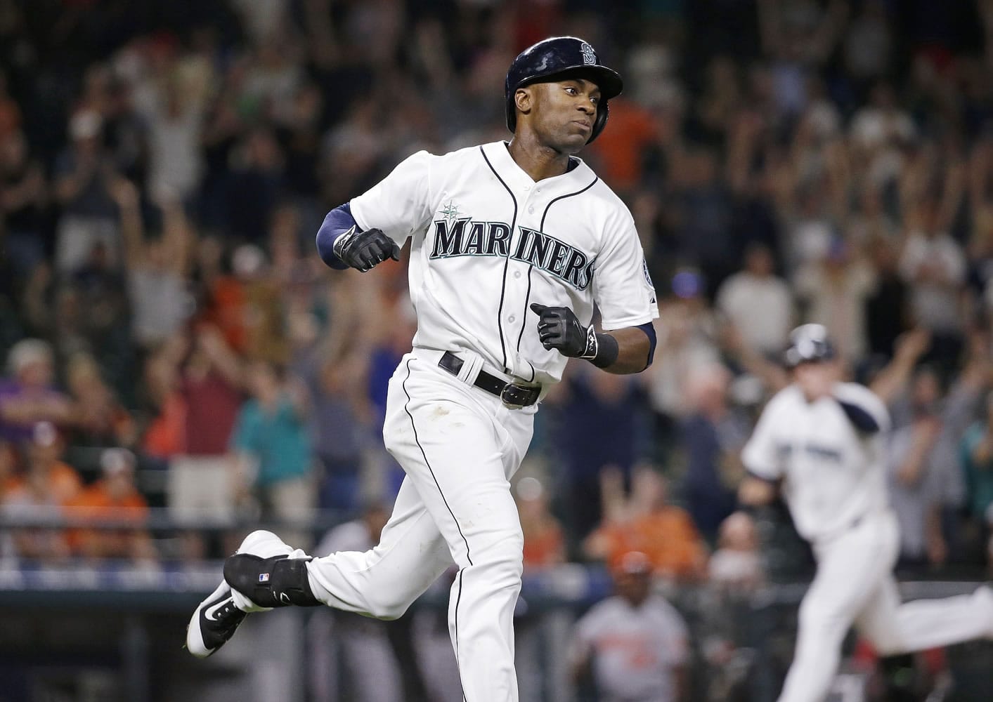 Seattle Mariners' Austin Jackson heads to first after knocking in the winning run as Logan Morrison heads home to score against the Baltimore Orioles in the 10th inning Tuesday, Aug. 11, 2015, in Seattle.