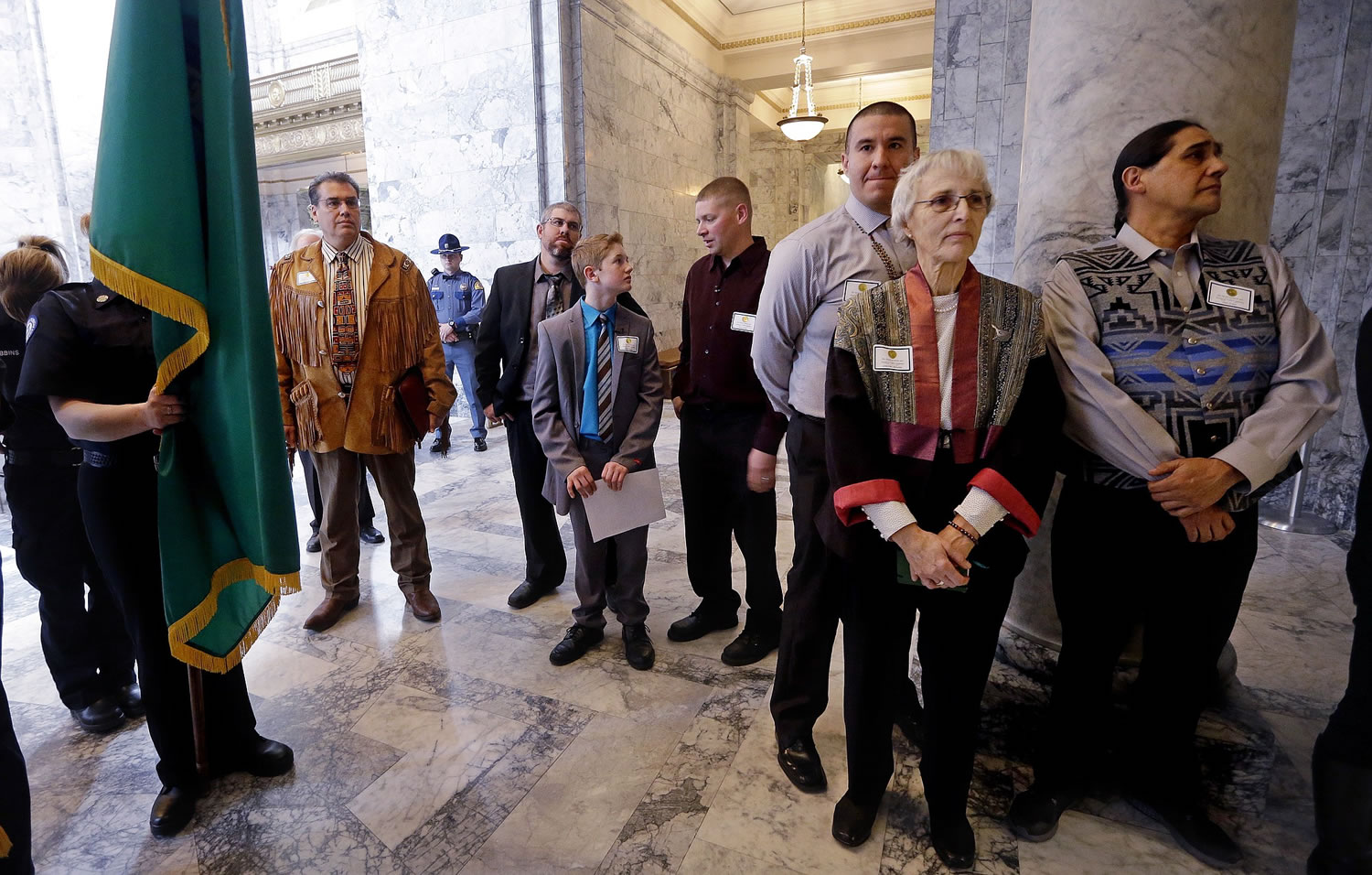 Award recipients stand outside the House Chamber as they wait to enter a joint session of the Washington state Legislature on Wednesday in Olympia. Medal of Valor recipients, from left, are Kevin Lenon, Quinn Nations, Brantly Stupey and Willy Harper and Medal of Merit recipients Gretchen Schodde, second right, and brothers Tobin, right, and Willie Frank, who accepted on behalf of their father Billy Frank Jr. Gov.