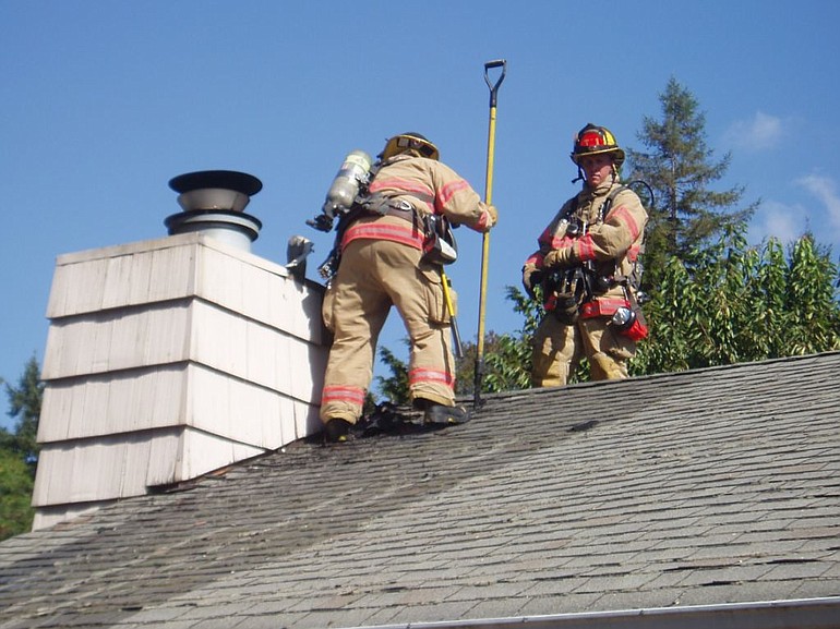 Vancouver firefighters examine the roof of a home that suffered $25,000 in fire damage Saturday.