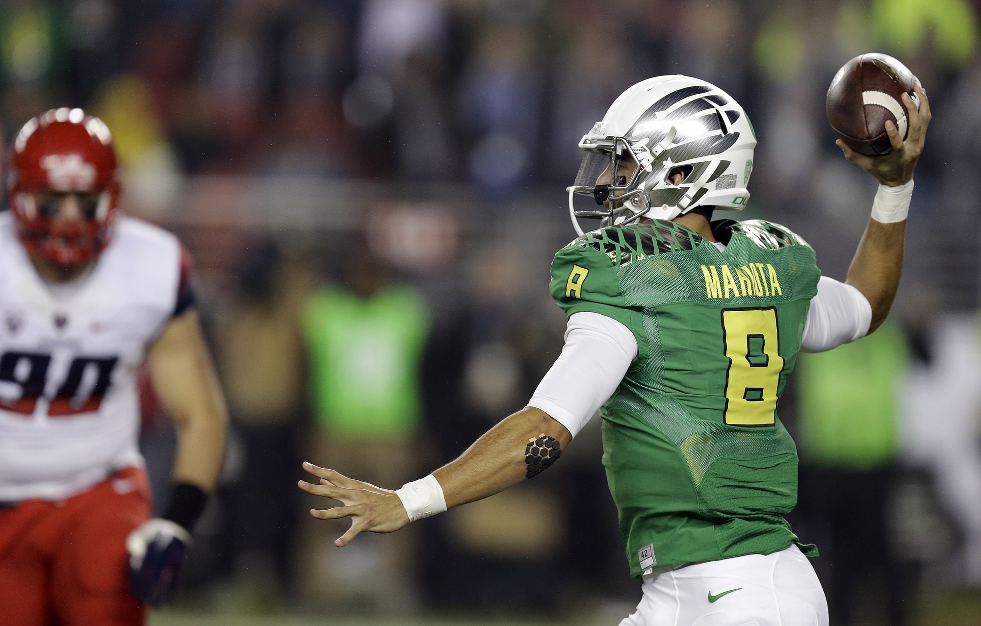 Oregon's Marcus Mariota, right, passes against Arizona during the first half of the Pac-12 Conference championship on Friday, Dec. 5, 2014, in Santa Clara, Calif.