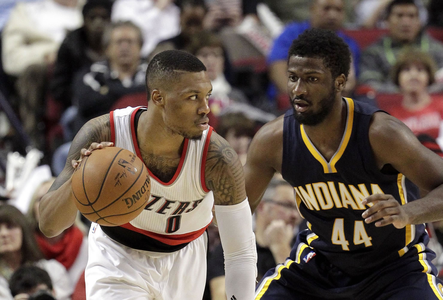 Portland Trail Blazers guard Damian Lillard, left, drives against Indiana Pacers forward Solomon Hill during the second half Thursday, Dec. 4, 2014. Lillard led the Trail Blazers in scoring with 23 points as they beat the Pacers 88-82.