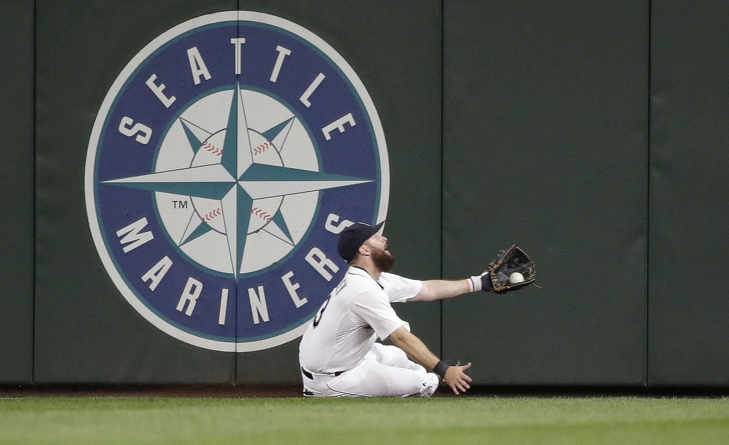 Seattle center fielder Dustin Ackley slides to make a catch of a deep fly ball from San Diego's Will Middlebrooks during the sixth inning.