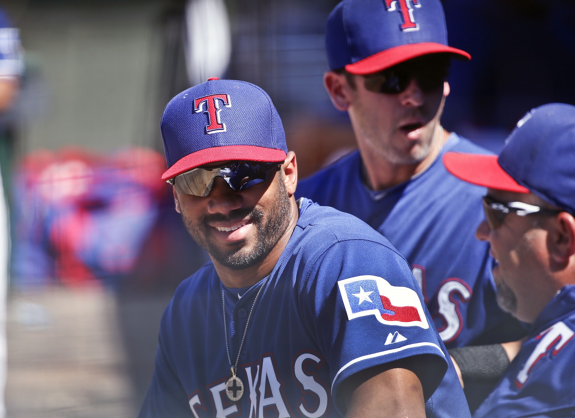 Seahawks quarterback Russell Wilson talks with fellow Texas Rangers in the dugout during a spring training game.