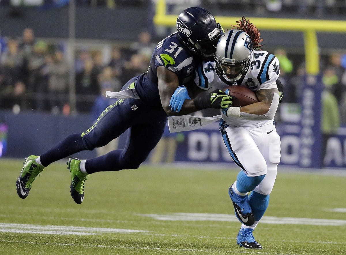 Seattle's Kam Chancellor (31) dives to take down Carolina's DeAngelo Williams during the NFL divisional playoff game.