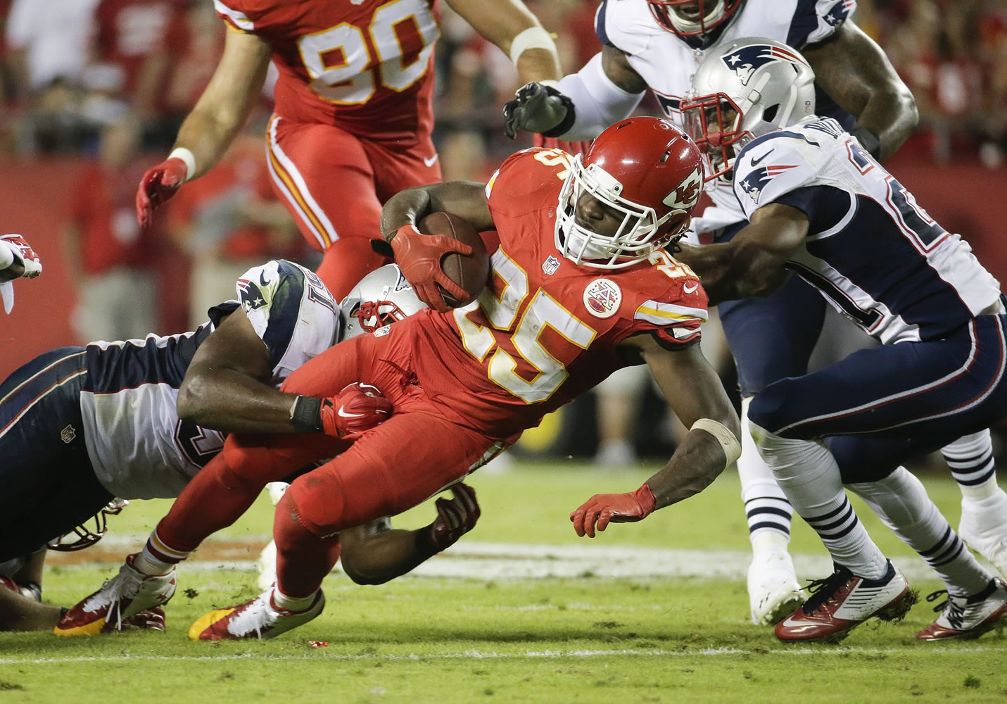Kansas City Chiefs running back Jamaal Charles, center, runs with the ball as New England Patriots linebacker Jerod Mayo, left, and defensive back Malcolm Butler, right, defend during the third quarter Monday, Sept. 29, 2014, in Kansas City, Mo.