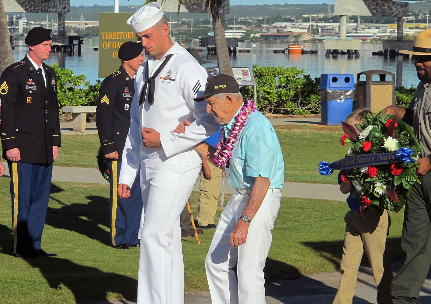 A Navy sailor escorts Navy veteran and Pearl Harbor survivor John Chapman during a ceremony to mark the 73rd anniversary of the Japanese attack on Pearl Harbor on Sunday at Pearl Harbor, Hawaii. The attack launched the U.S.